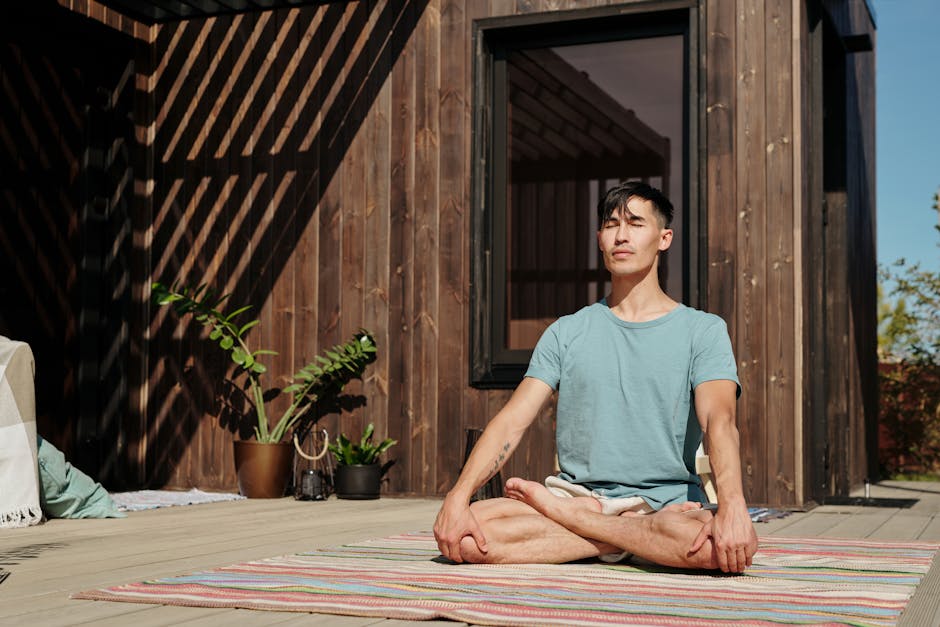Man meditating outdoors with closed eyes, enjoying a peaceful moment on a sunny day.